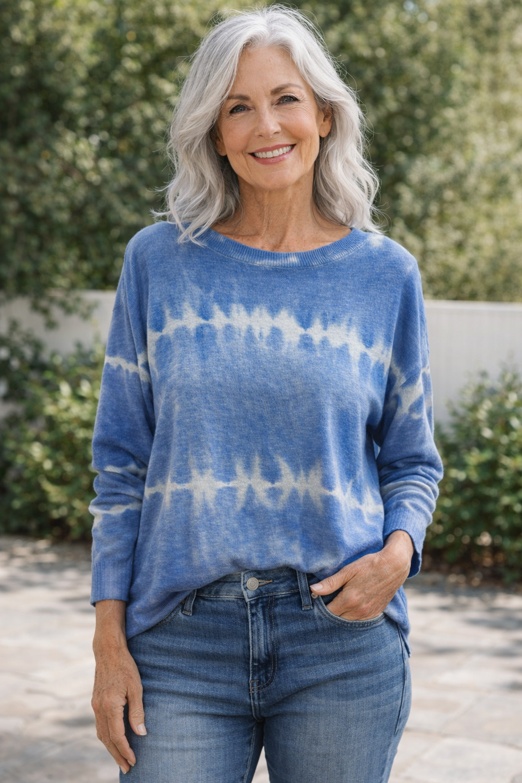 Older woman with silver hair wearing a blue and white tie-dye lightweight sweater styled with jeans from Ellen Jane Boutique in Port St. Lucie.