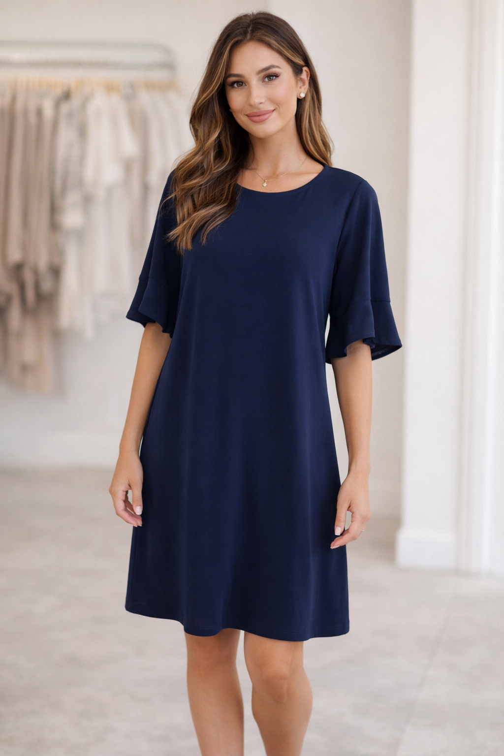 Young woman modeling a navy blue ruffle sleeve knee-length dress from Ellen Jane Boutique, featuring a relaxed fit and elegant feminine silhouette.